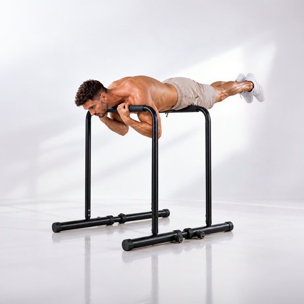Sportler hält auf den Holmen der PT500 eine gestreckte Planche-Position