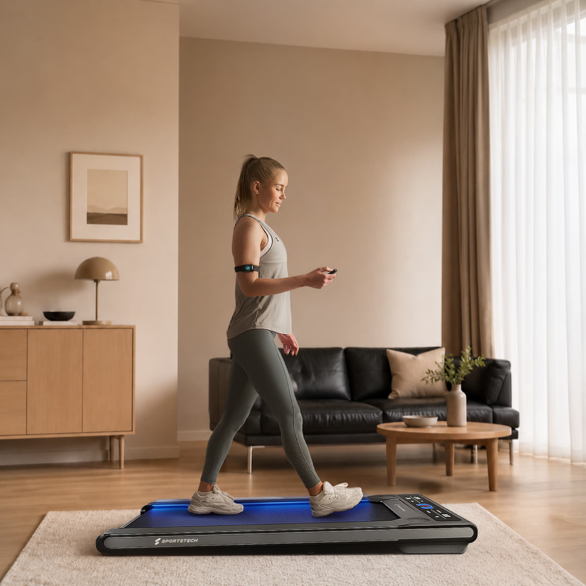 Frau geht auf dem flachen sWalk Walking Pad im Wohnzimmer und hält eine Fernbedienung