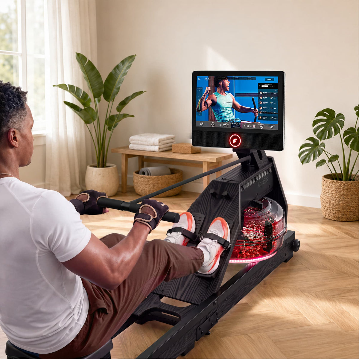 Mann rudert am schwarzen Aqua Elite mit rot beleuchtetem Tank, Trainerkurs auf 21,5-Zoll-Display