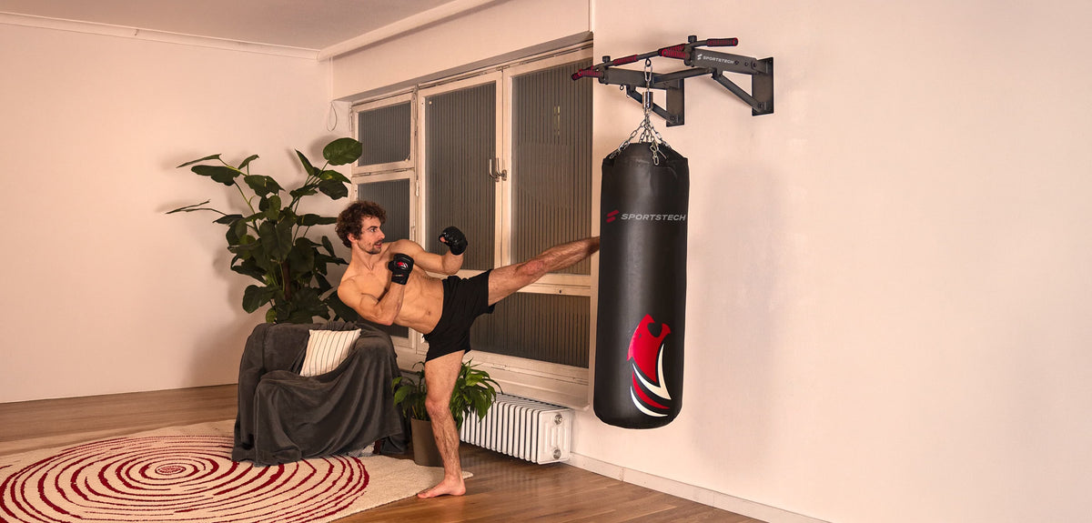 Mann beim Kickbox-Training am Boxsack, der an der Sportstech KS350 Klimmzugstange hängt
