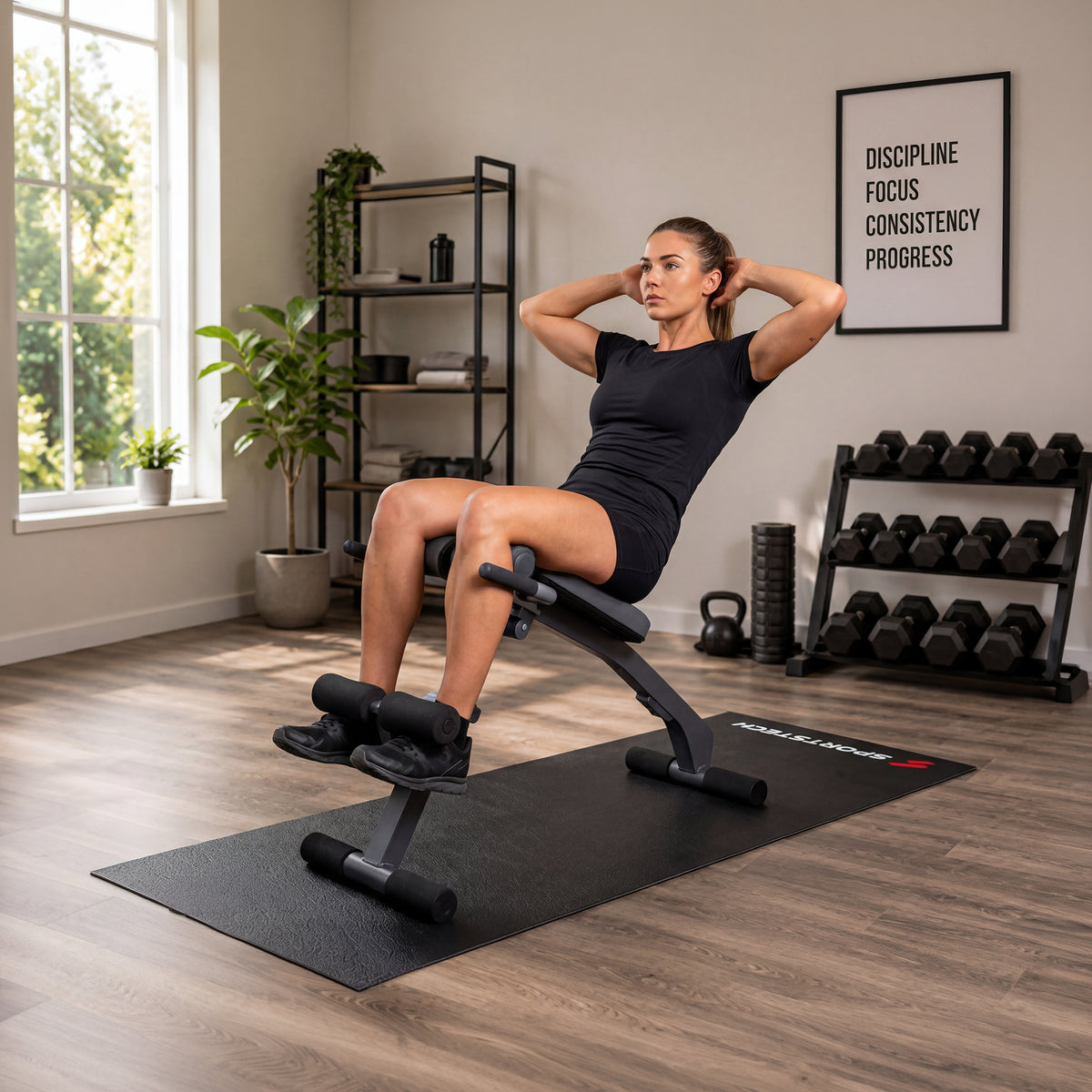 Frau trainiert auf einer Bank samt Bodenschutzmatte in einem Fitnessraum mit Hantelablage und Motivationsposter