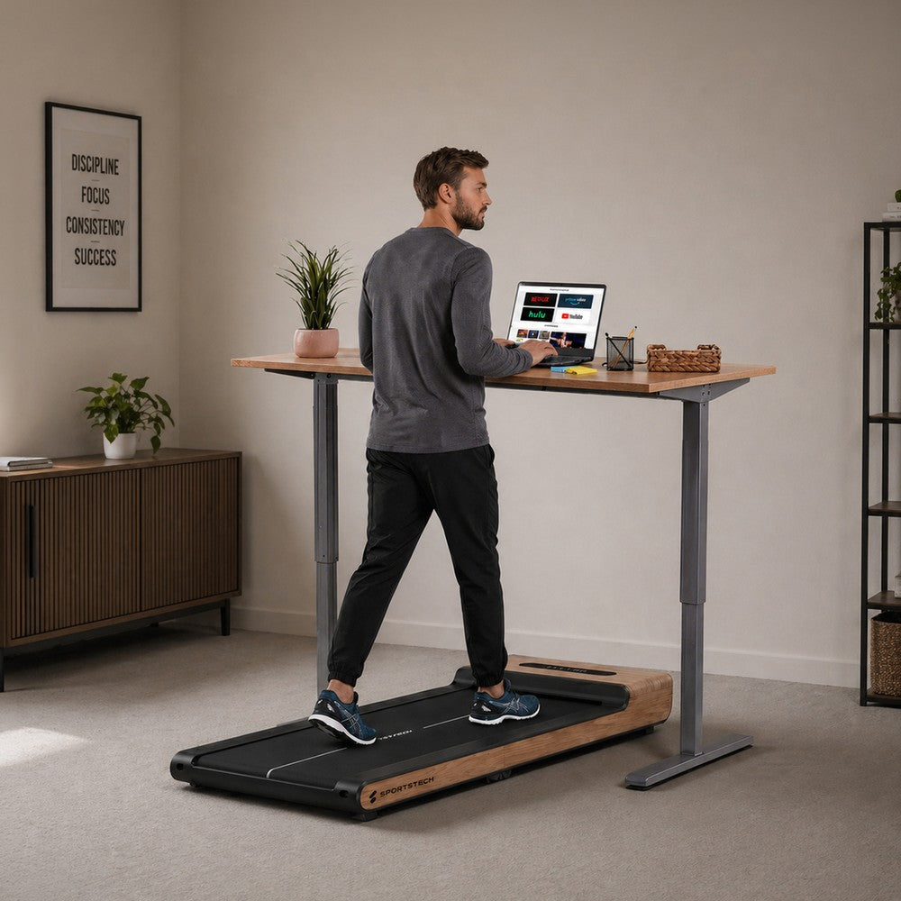 Sportstech WoodPad Pro Laufband unter einem Stehschreibtisch im Wohnraum, Mann beim Walking