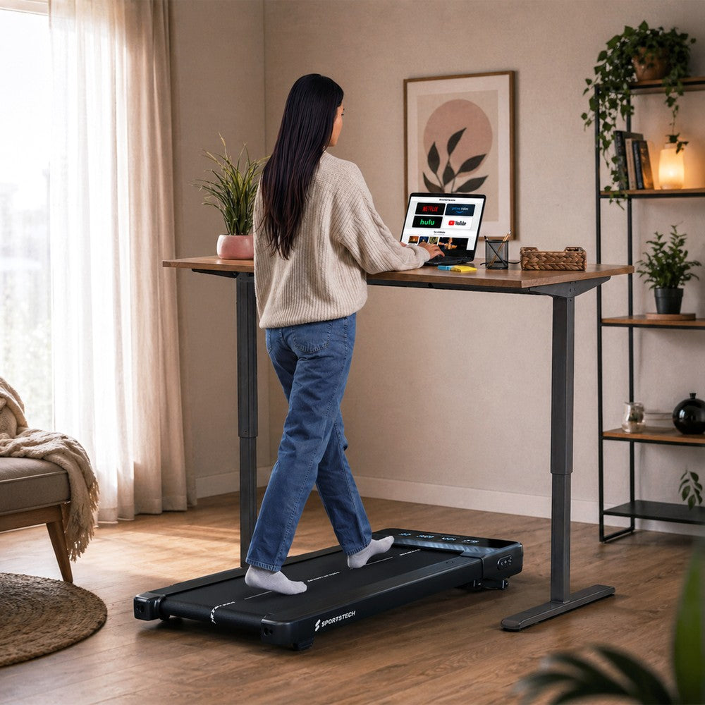 Sportstech sPad500 Laufband unter einem Stehschreibtisch im Wohnraum, Frau beim Walking