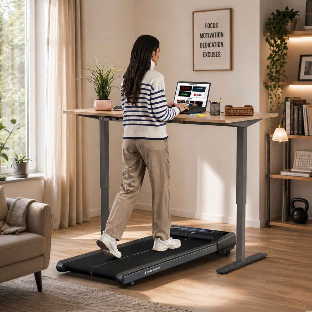 Sportstech sWalk Lite Laufband unter einem Stehschreibtisch im Wohnraum, Frau beim Walking