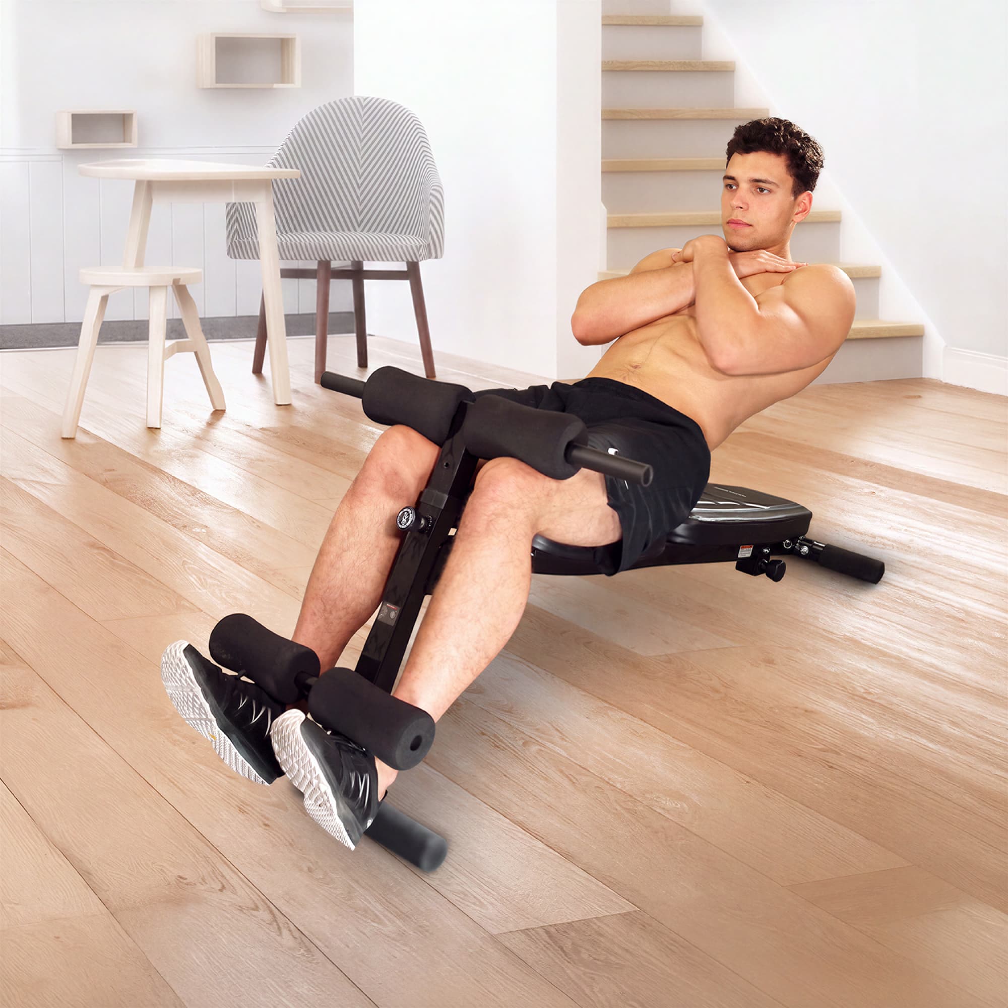 Mann macht Sit-ups auf der negativ geneigten BRT500 Hantelbank mit fixierten Füßen unter den Beinrollen