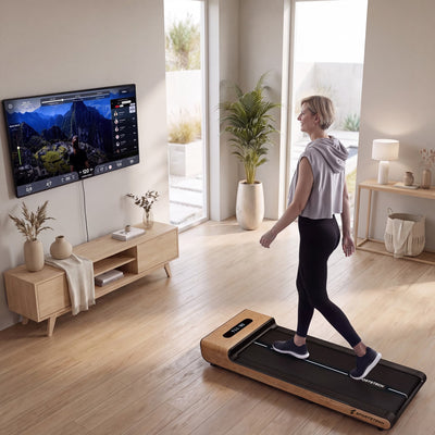 Frau geht auf hellbraunem WoodPad Pro im Wohnzimmer, an der Wand Trainings-Display