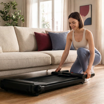 Frau klappt das sProRun Laufband zusammen und verstaut es flach neben dem Sofa im Wohnzimmer