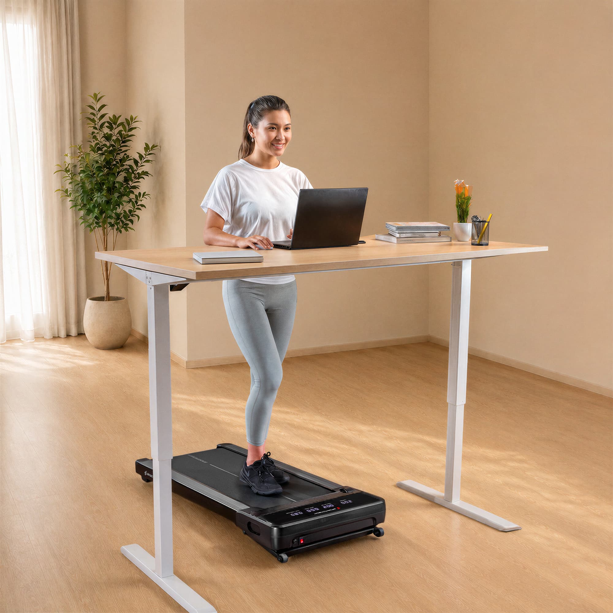 Frau am Laptop geht am Stehschreibtisch auf dem flachen sPad500 Walking Pad in hellem Raum