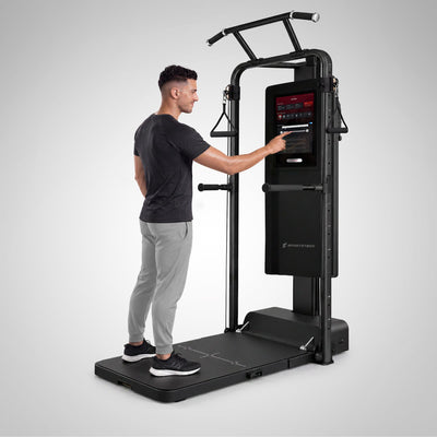 Mann stellt am Touchscreen der sGym Pro das Gewicht ein, Gerät ganz im Bild