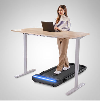 Frau am Laptop läuft am Stehschreibtisch auf dem sWalk Lite Plus Laufband mit blau leuchtender Leiste