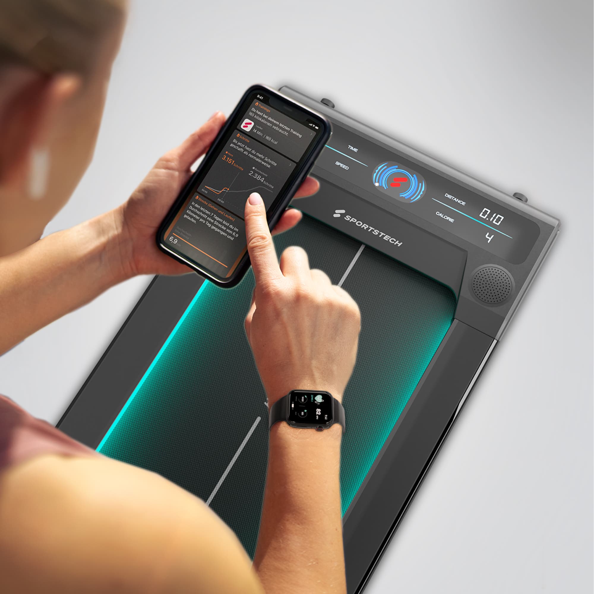 Person bedient die Sportstech-App am Smartphone neben dem sWalk-Display mit türkiser Beleuchtung