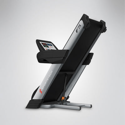 F75 Profi-Laufband seitlich hochgeklappt, Klappmechanismus mit Zylinder und Display sichtbar