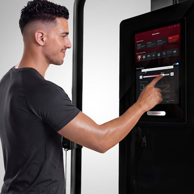 Mann bedient den Touchscreen der sGym Pro mit geöffnetem Quick-Start-Menü und Gewichtseinstellungen