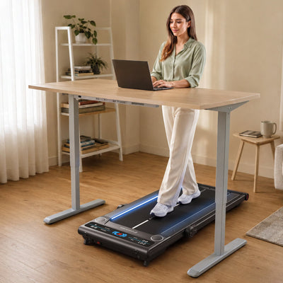 Frau geht am Laptop stehend auf dem flachen sWalk Plus Laufband unter einem Stehschreibtisch