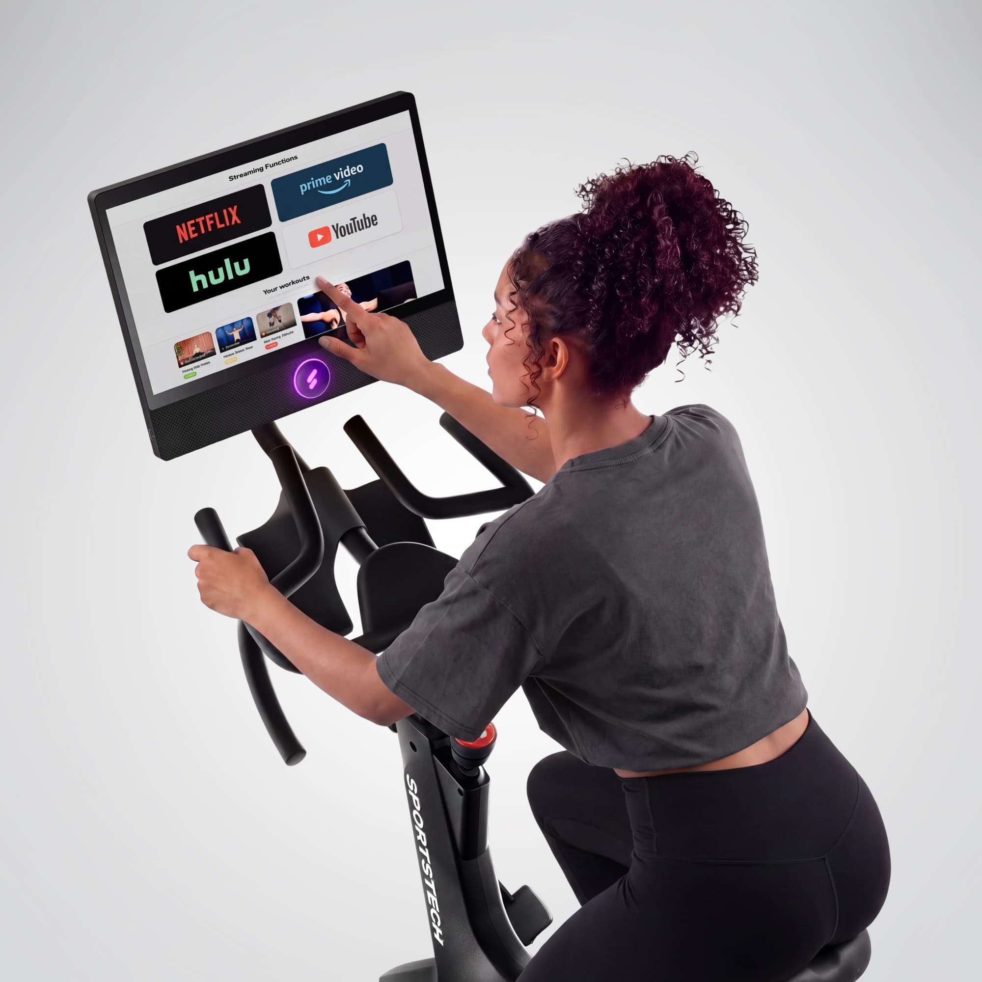 Frau bedient das sBike-Display mit Streaming-Apps wie Netflix, YouTube und Prime Video