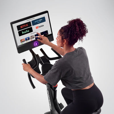 Frau bedient das sBike-Display mit Streaming-Apps wie Netflix, YouTube und Prime Video