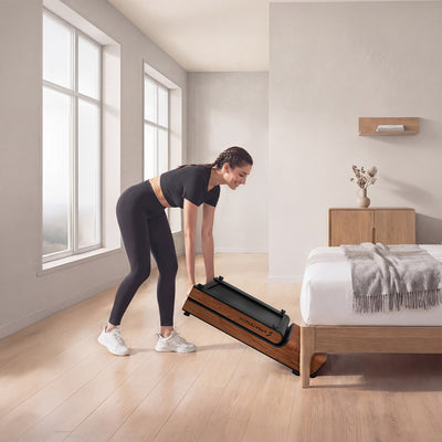 Frau stellt zusammengeklapptes dunkelbraunes WoodPad Pro hochkant im Schlafzimmer ab