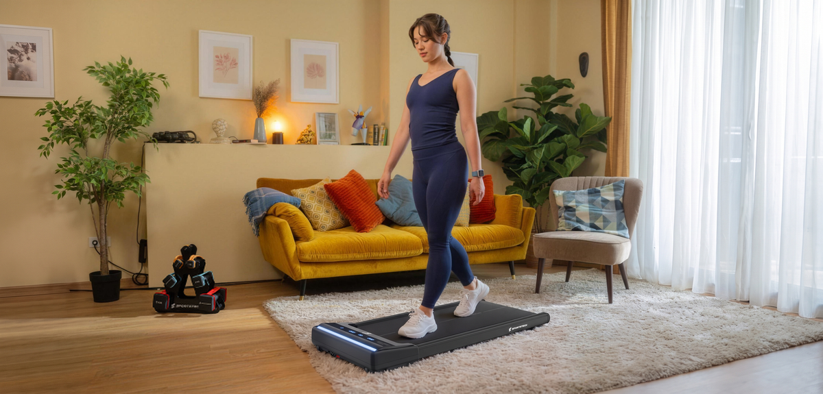 Frau geht auf dem schwarzen sWalk Lite Walking Pad im hellen Wohnzimmer