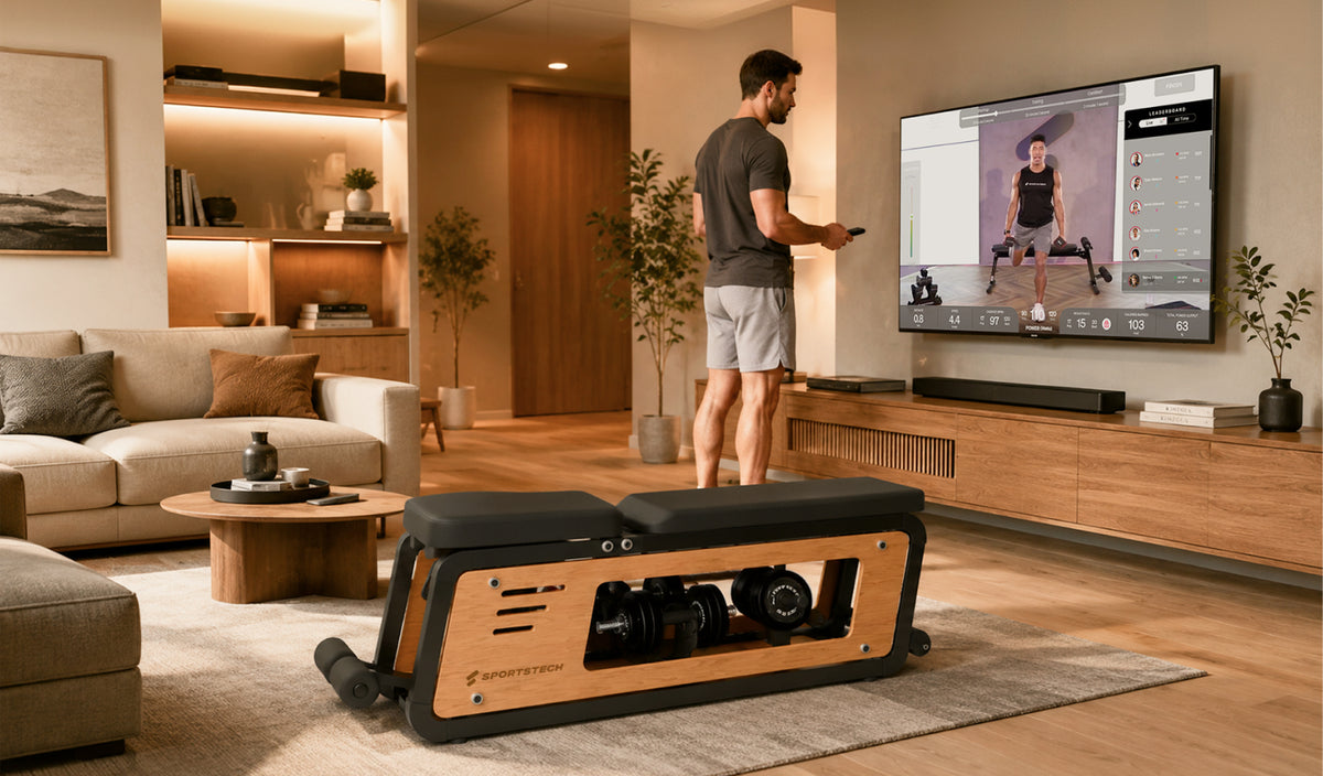 Mann startet ein Sportstech Live Workout am TV neben der Woodmate Lite Hantelbank