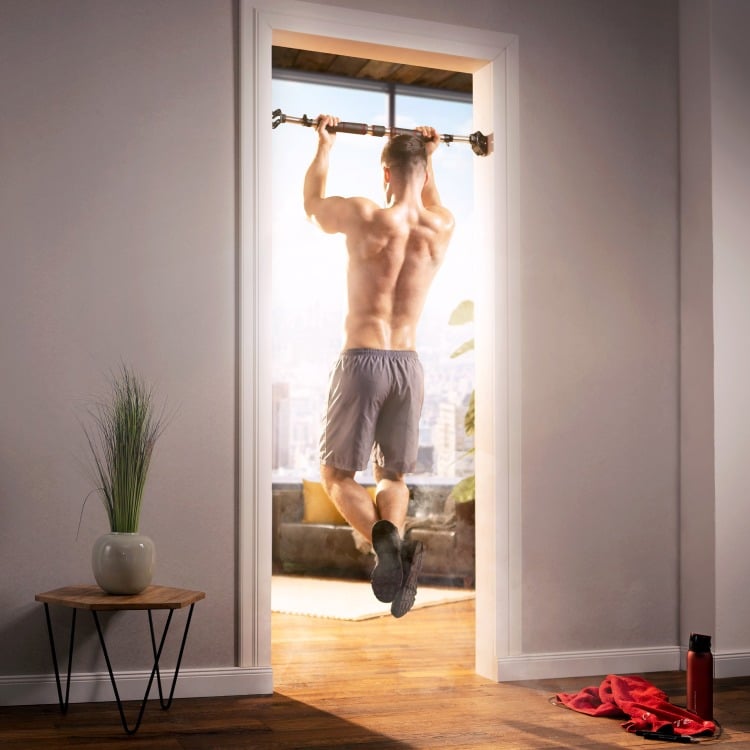 Mann hängend auf Klimmzugstange von hinten